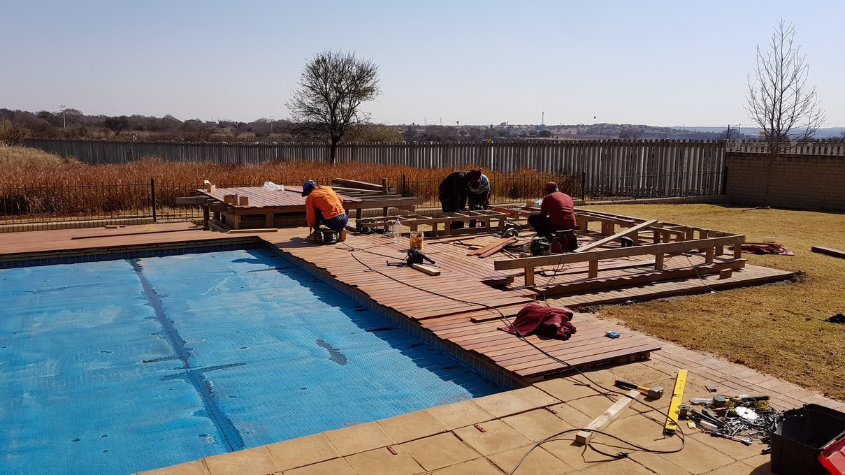 Timbermann employees and professional tools in action as they build a sleek red ironbark pool and boma deck.