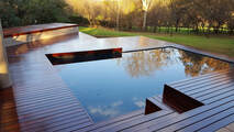 A Timbermann-constructed pool deck is positioned in an outdoor area.